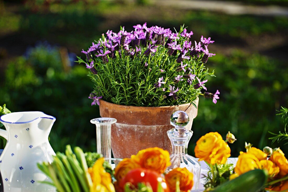 Fresh vegetables and flowers on a summery table outside