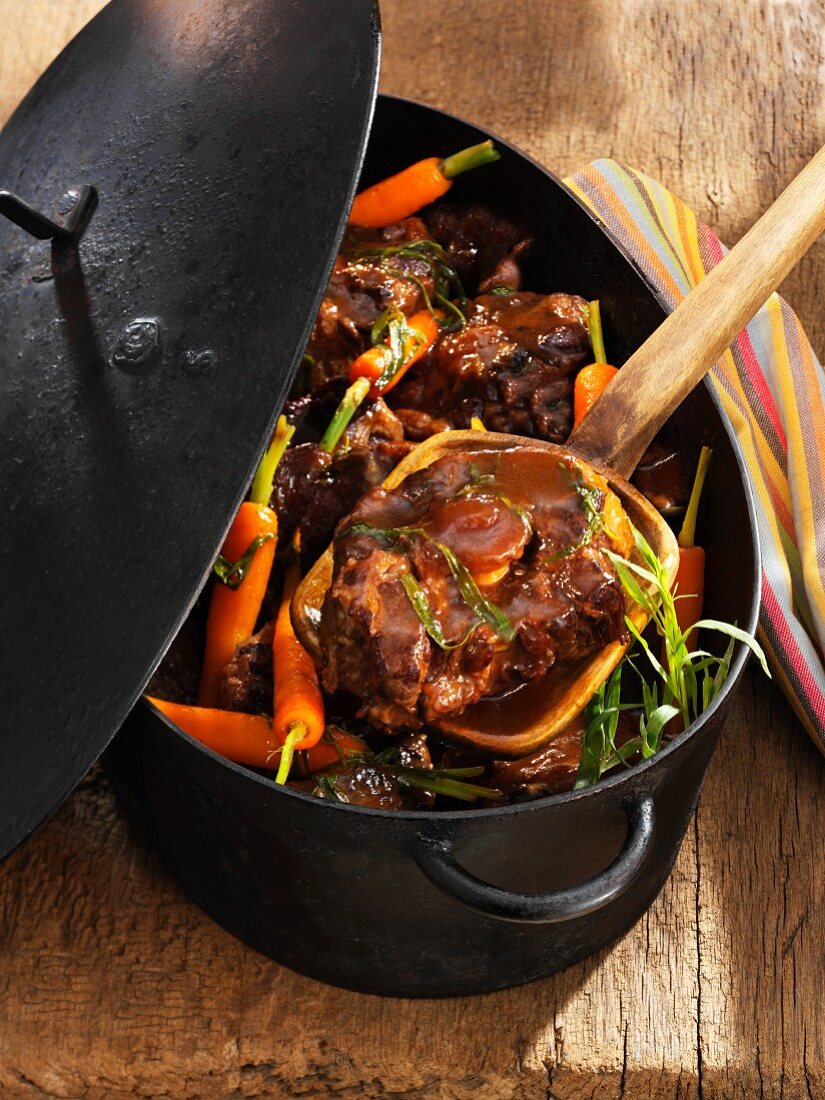 Oxtail ragout with carrots in a stewing pot
