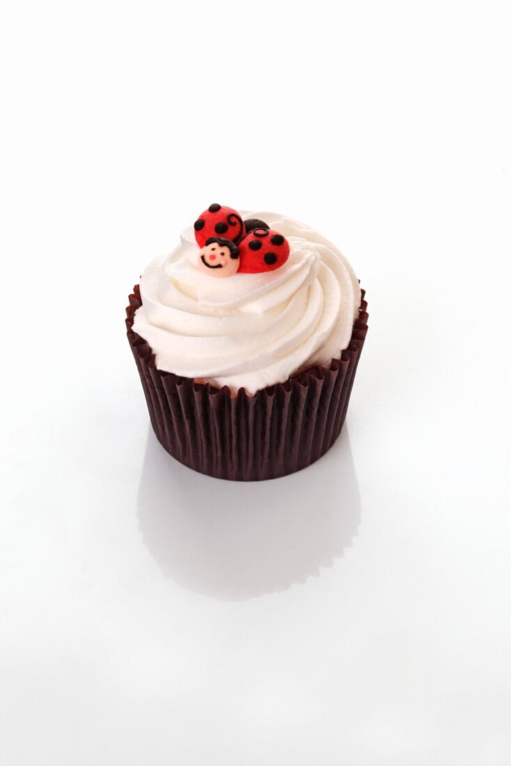 A cupcake decorated with ladybirds