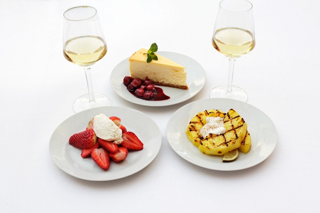 Cheesecake, strawberries and grilled pineapple with glasses of wine