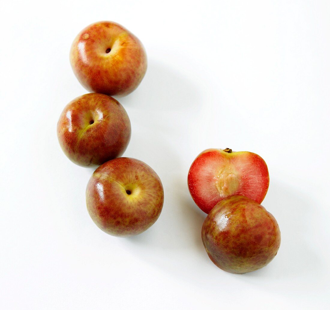 Fresh Whole Loquat Fruit; One Halved; White Background
