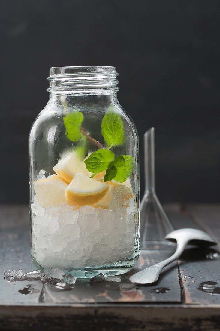 Crushed Ice mit Zitronenstücken und Minze in einem Schraubglas