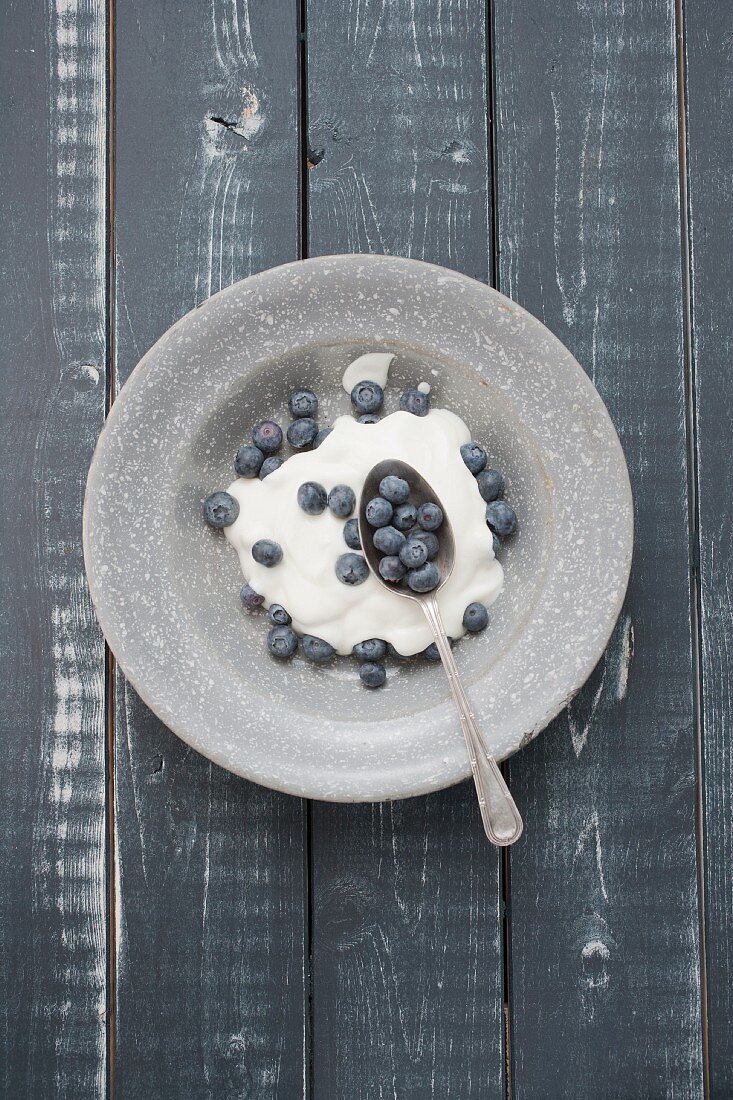 Blueberries and yoghurt in a grey enamel bowl