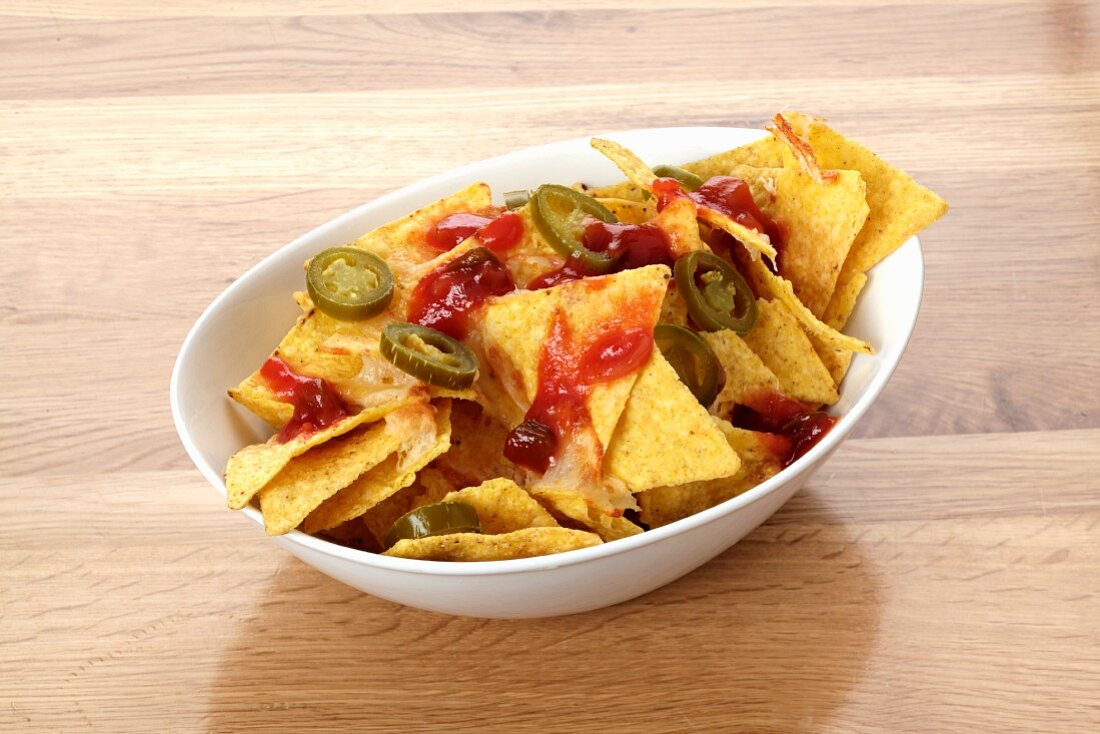 Tortilla chips with barbecue sauce and jalapeños