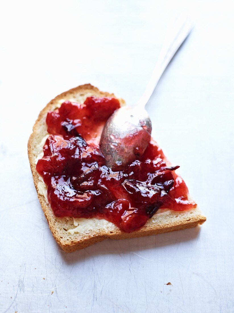 A slice of bread topped with damson jam