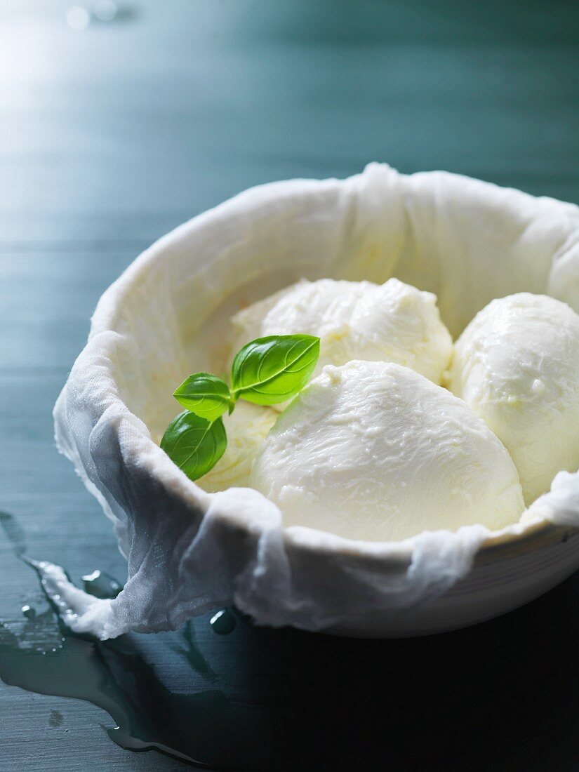 Mozzarella in a bowl lined with a muslin cloth
