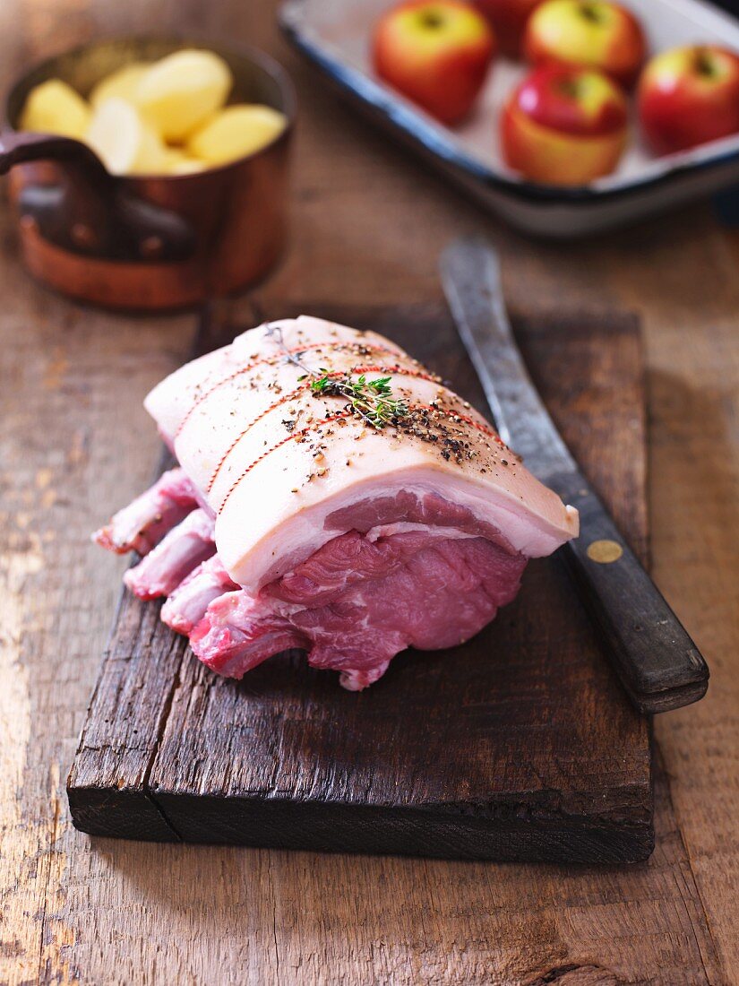 Ready-to-roast rack of pork on a wooden board