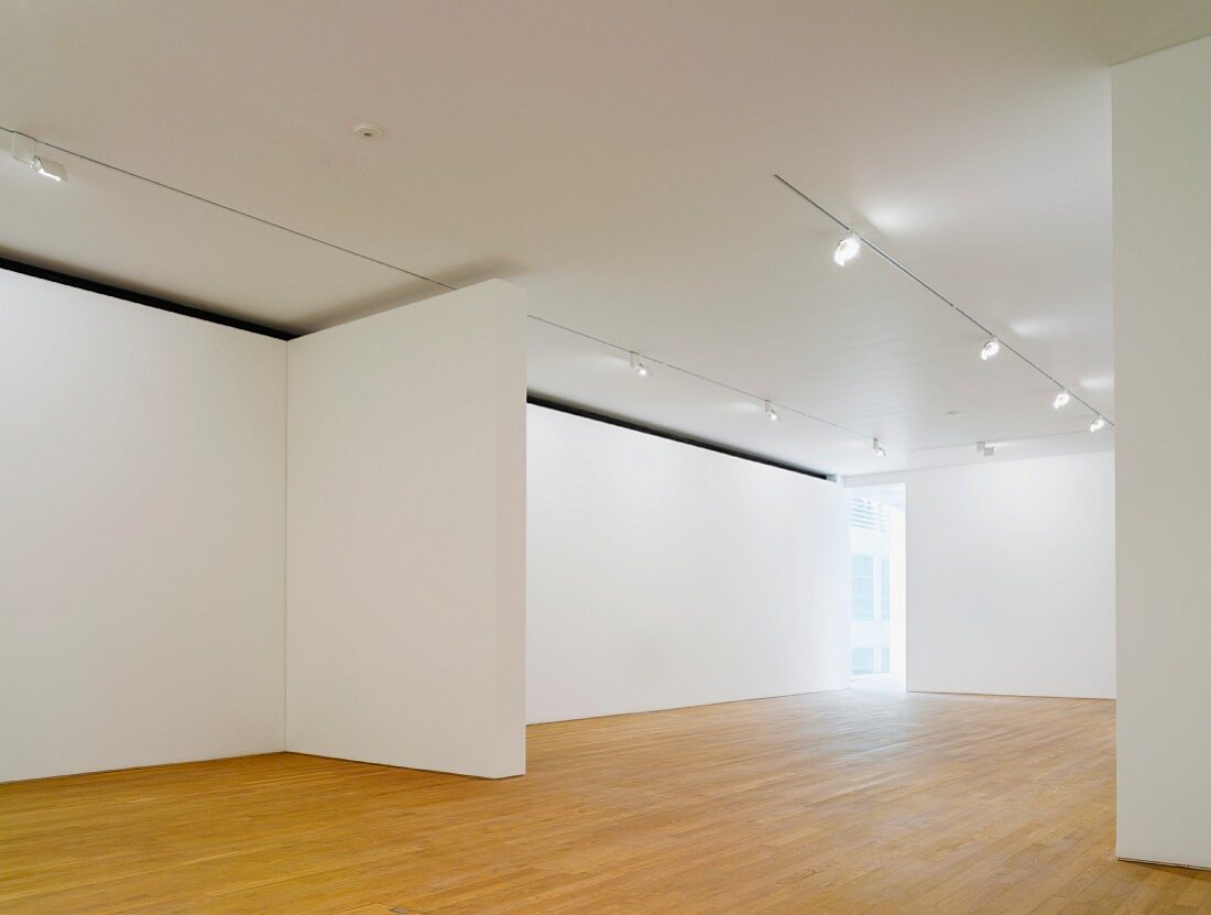Empty gallery space lit with spotlights on a suspended ceiling and wood flooring (Photographers' Gallery, London)