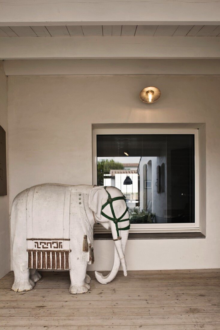 Sculpture of an elephant in a lobby with a window