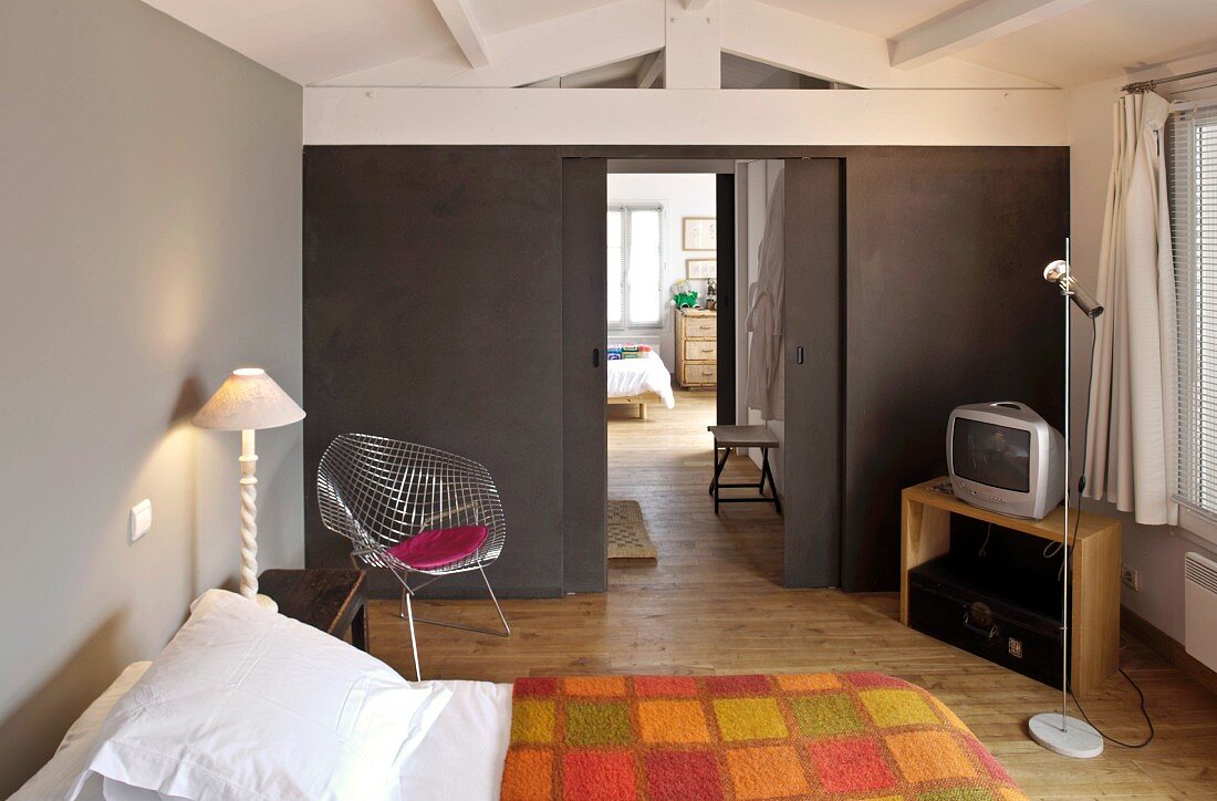 Modern bedroom with gray walls and classic chairs in the corner of the room