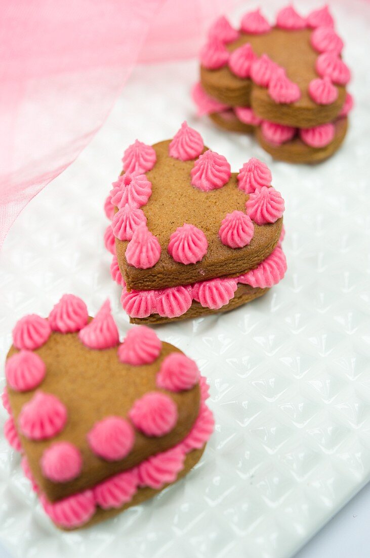 Heart-shaped sponge cakes decorated with pink cream