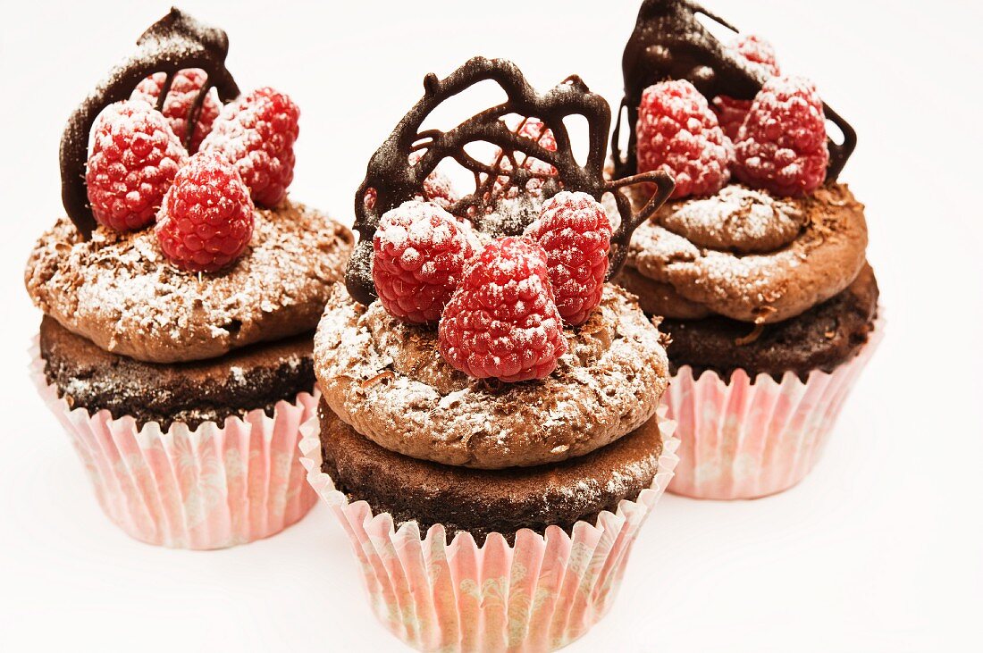 Chocolate cupcakes with raspberries and chocolate decoration