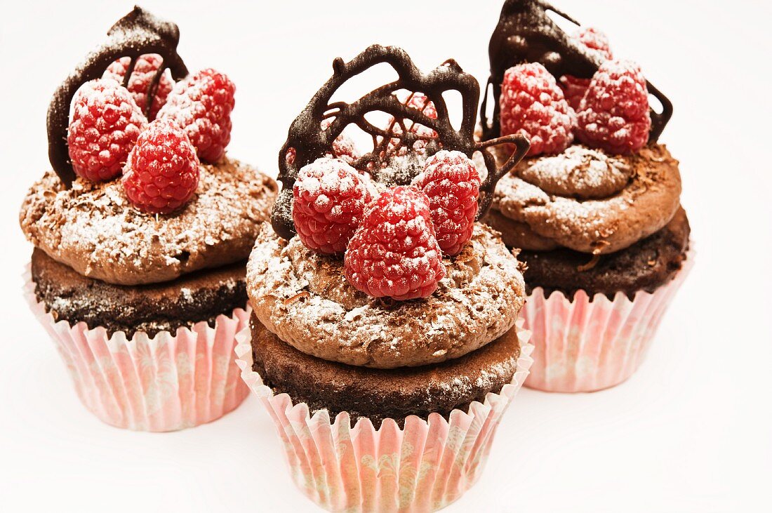 Schokoladen-Cupcakes mit Himbeeren und Schoko-Ornament