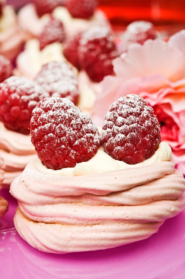 Pink meringues with cream and fresh raspberries