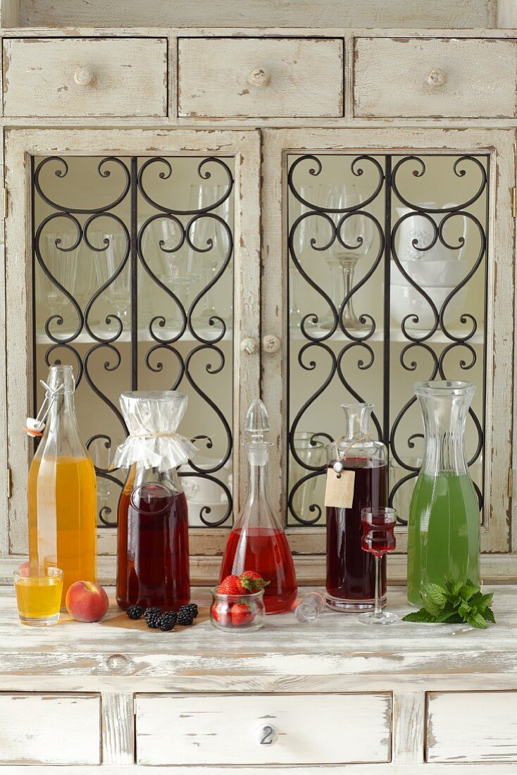 Various types of homemade liqueur: apricot, blackberry, strawberry, chokeberry and mint