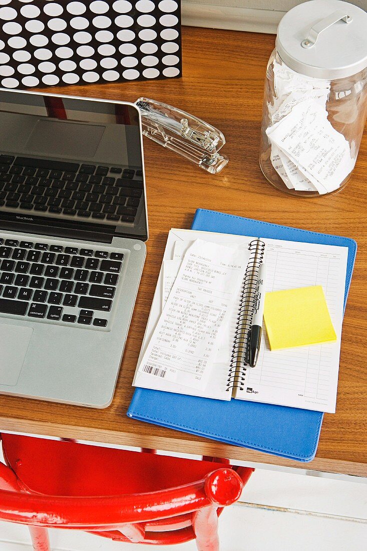 Laptop and open notebook on desk