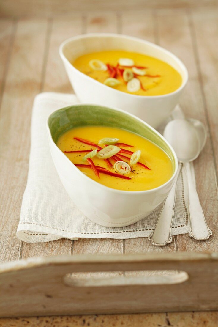 Cream of pumpkin soup with chilli strips and spring onions