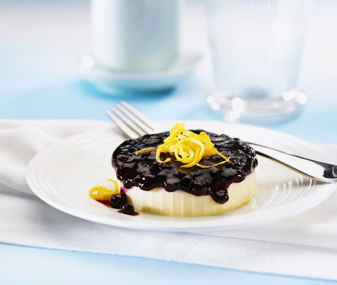 A small lemon cheesecake with blueberry sauce