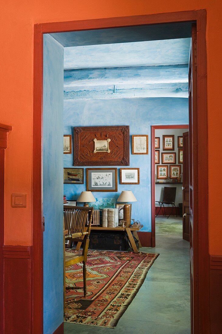 View through red doorway to blue study wth oriental rug