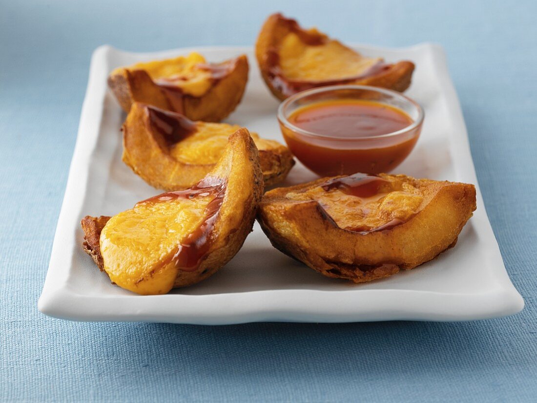 Ausgehöhlte Kartoffeln aus dem Ofen mit Käsesauce und Dip