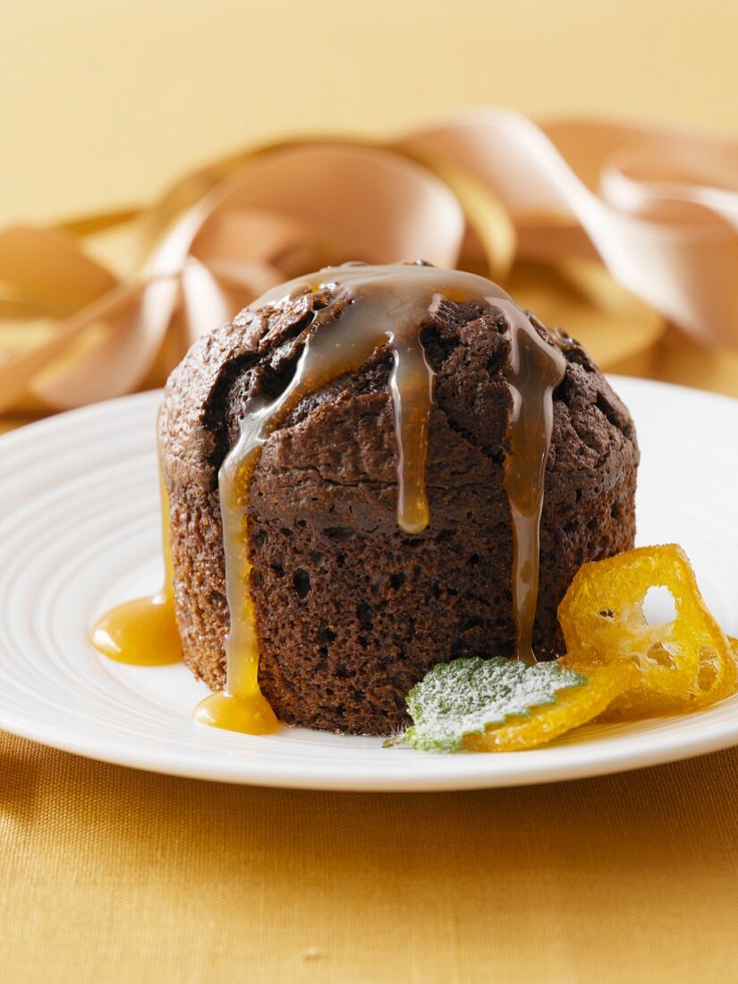 A chocolate muffin with caramel sauce