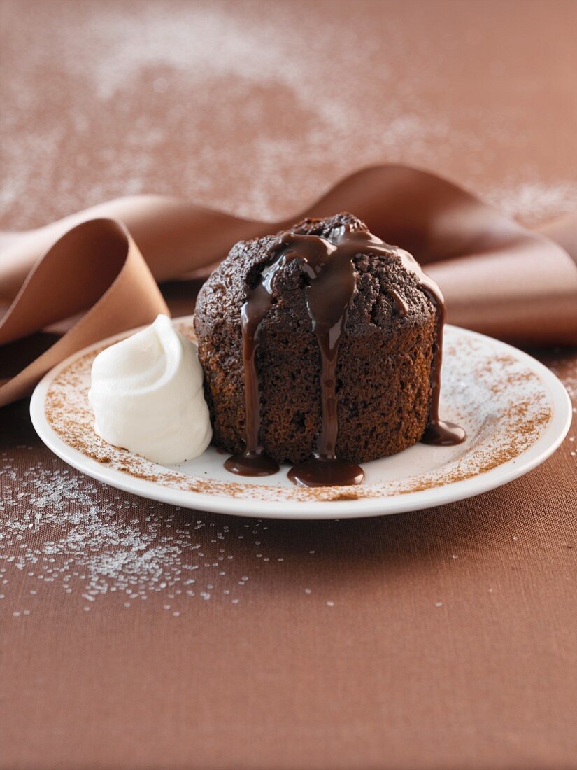 A chocolate cake with chocolate sauce and whipped cream