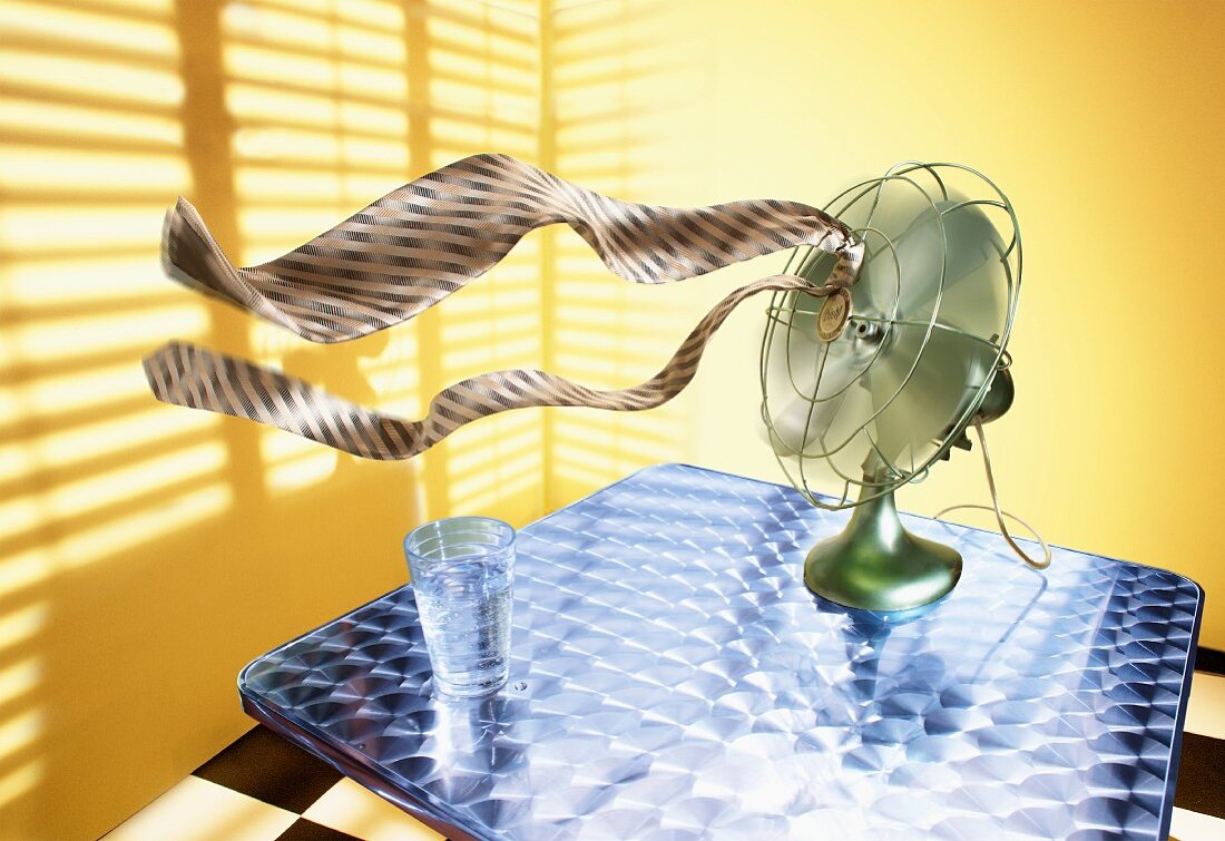 Mans Tie Blowing from Fan on a Table; Glass of Water
