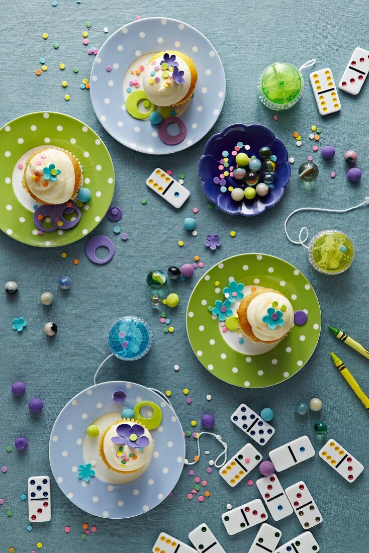 Bunte Cupcakes und Spielsachen auf einem Tisch