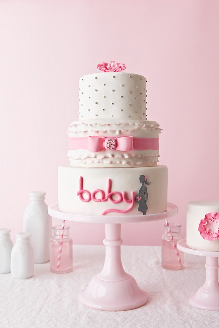 Dreistöckige weiße Torte mit rosa Zuckerschrift baby
