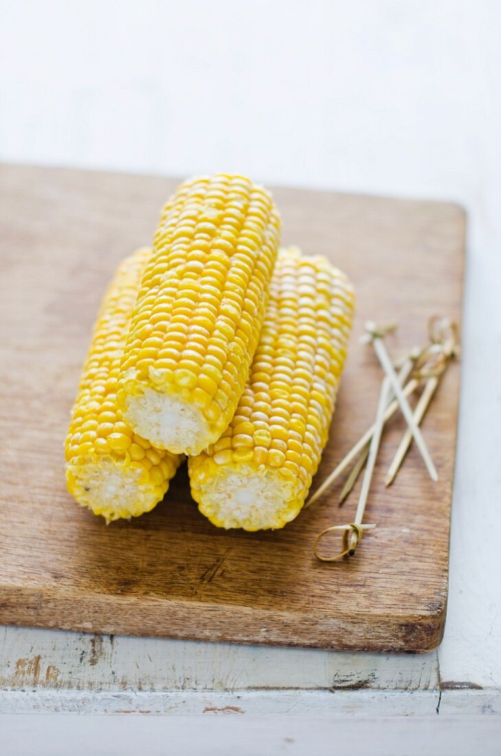 Three corn cobs and skewers