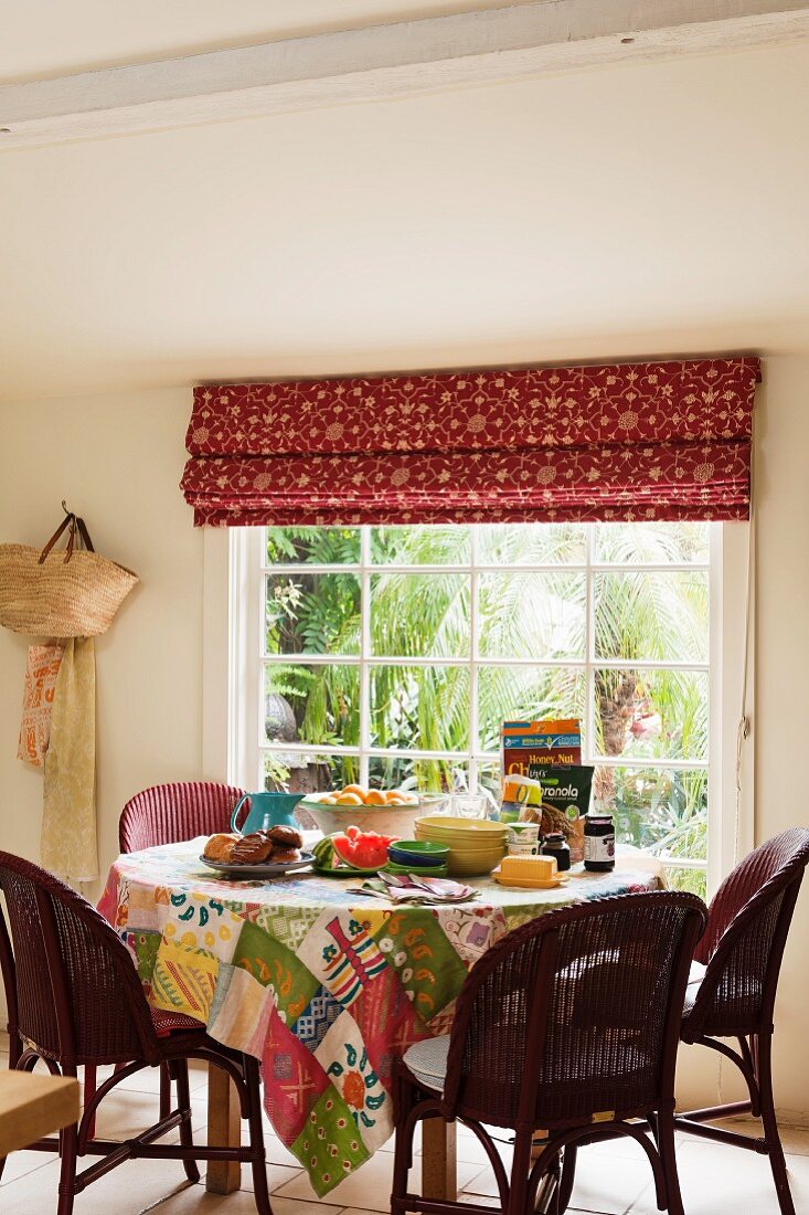 Breakfast table with patchwork tablecloth made from assorted Kathryn Ireland fabrics beneath window with Kathryn Ireland Sandeep blind fabric