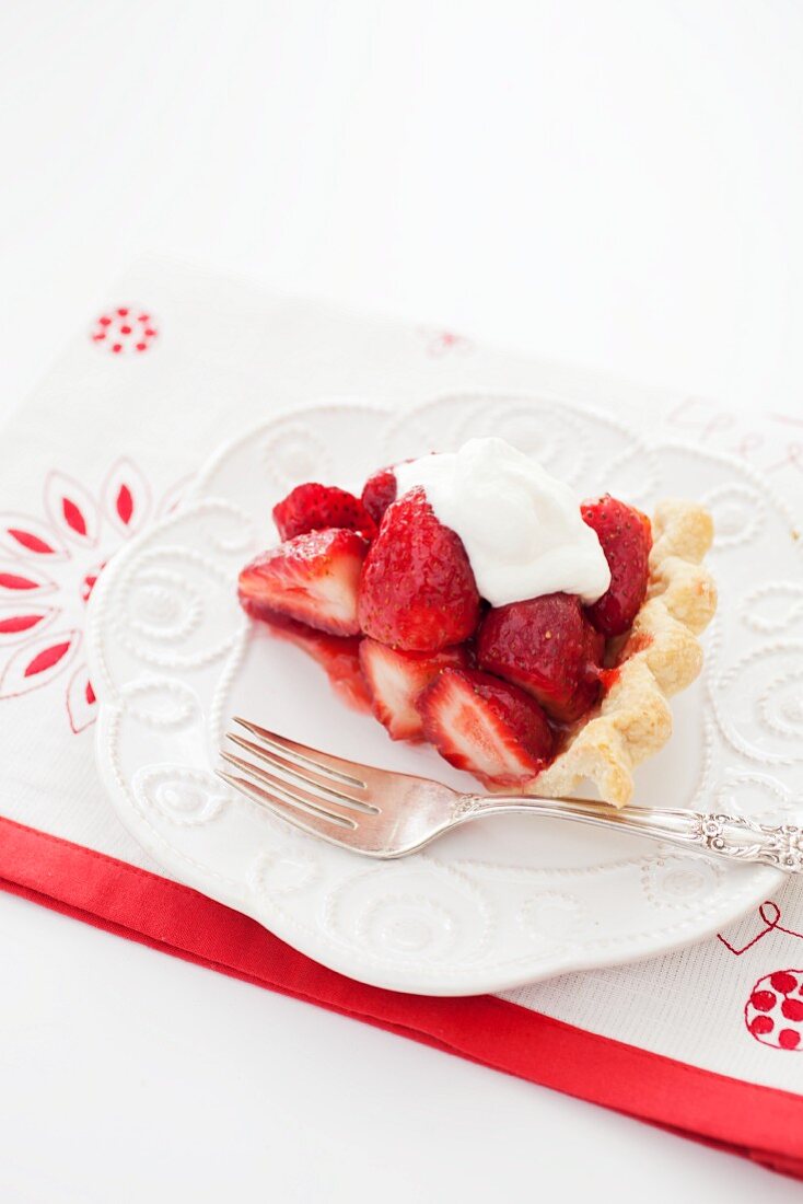 Slice of Fresh Strawberry Pie with Whipped Cream on a White Plate with a Fork
