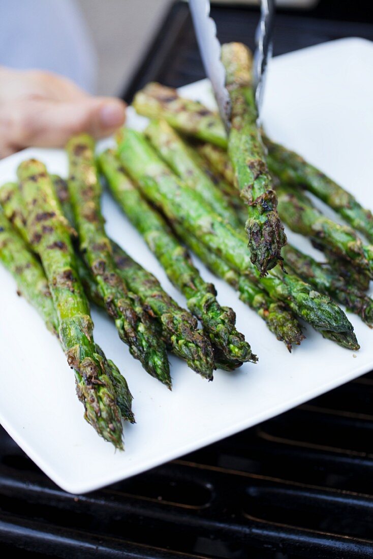 Removing Grilled Asparagus Spears from Grill and Placing on a Platter