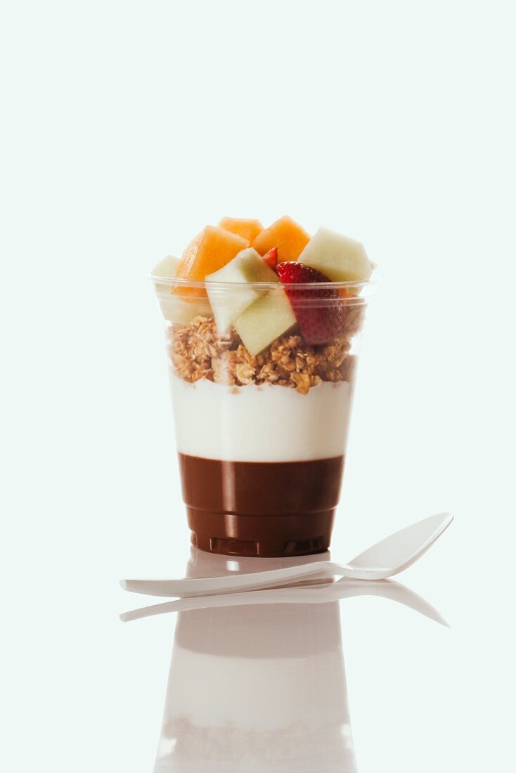 Chocolate and Plain Yogurt Topped with Granola and Fruit; In a Plastic Cup; Plastic Spoon
