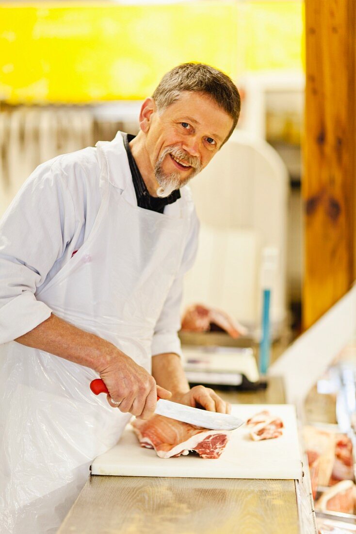 A butcher chopping pork