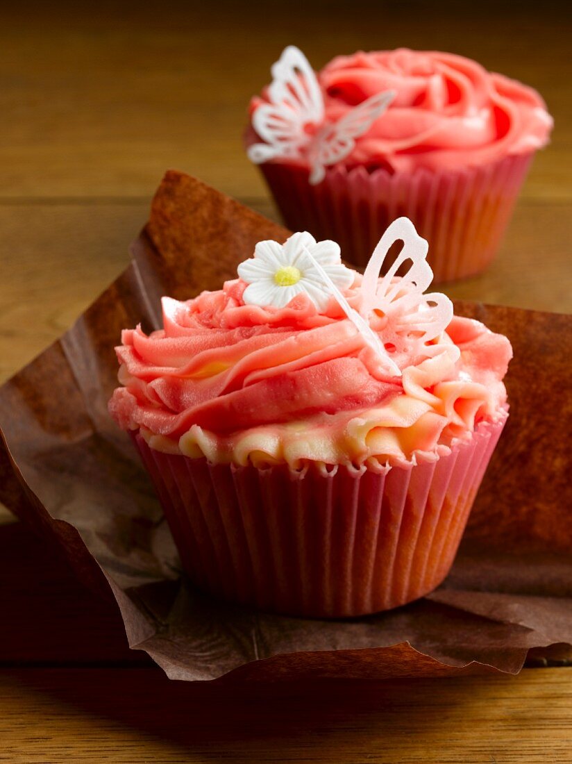Cupcake mit Erdbeercreme, Schmetterling und Zuckerblume