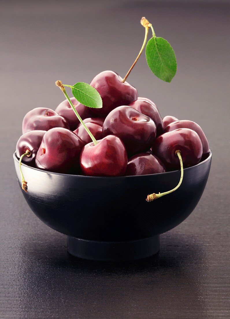 Fresh cherries in a black bowl