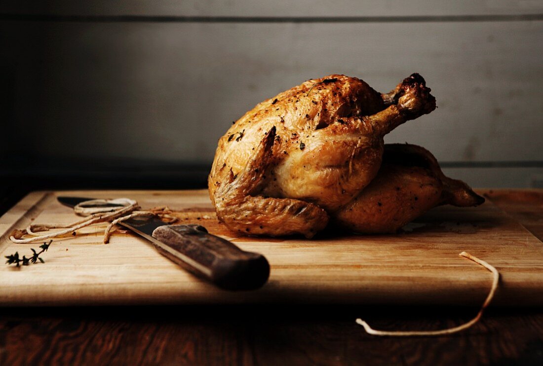 A Whole Roasted Chicken on Cutting Board