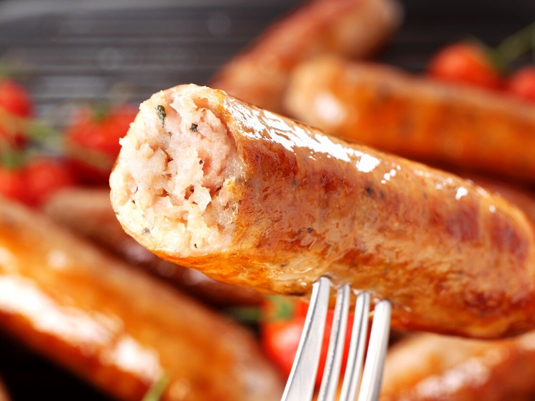 A Cumberland sausage on a fork (close-up)