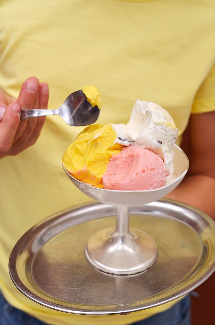 A girl holding a mixed ice cream sundae