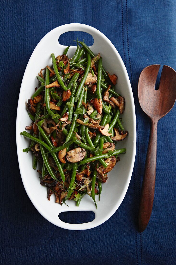 Sherried Green Beans and Mushrooms in a Serving Bowl; Wooden Serving Spoon