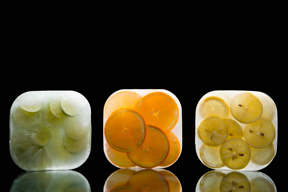 Limetten-, Orangen- und Zitronenscheiben in Eisblöcken