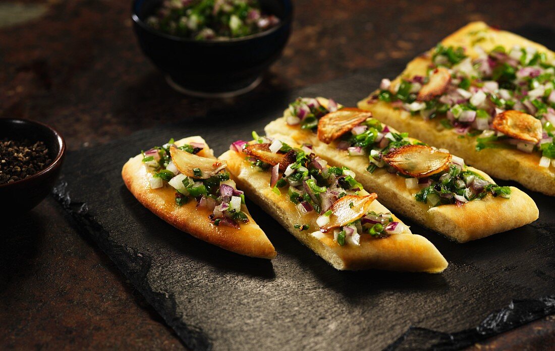 Unleavened bread topped with garlic, onions and herbs