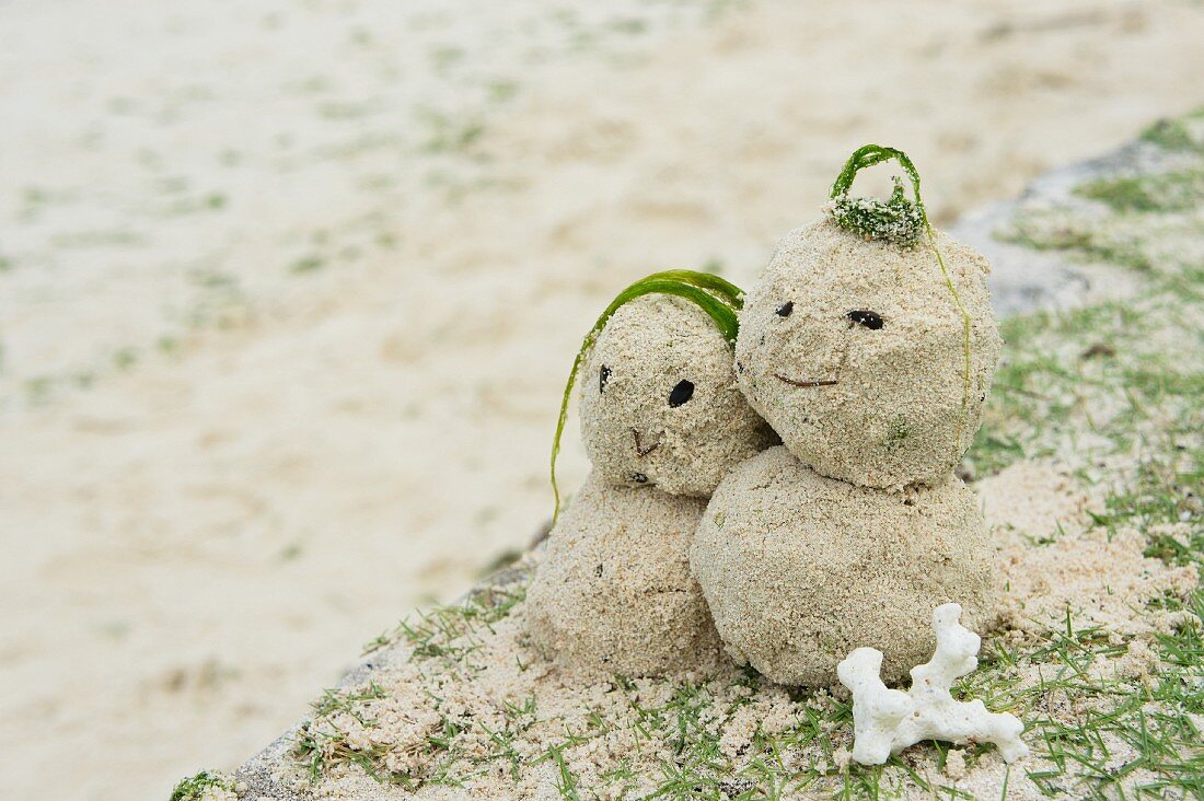 Sandfrau und Sandmann am Strand