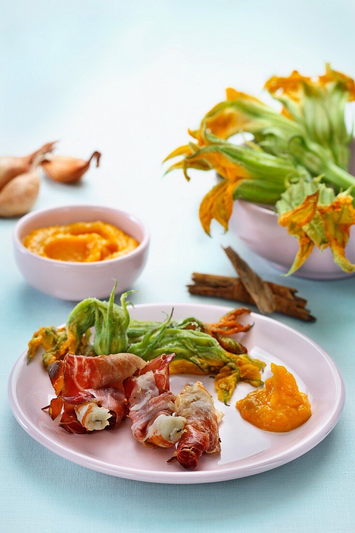 Scampi wrapped in ham with pumpkin sauce and fried pumpkin flowers