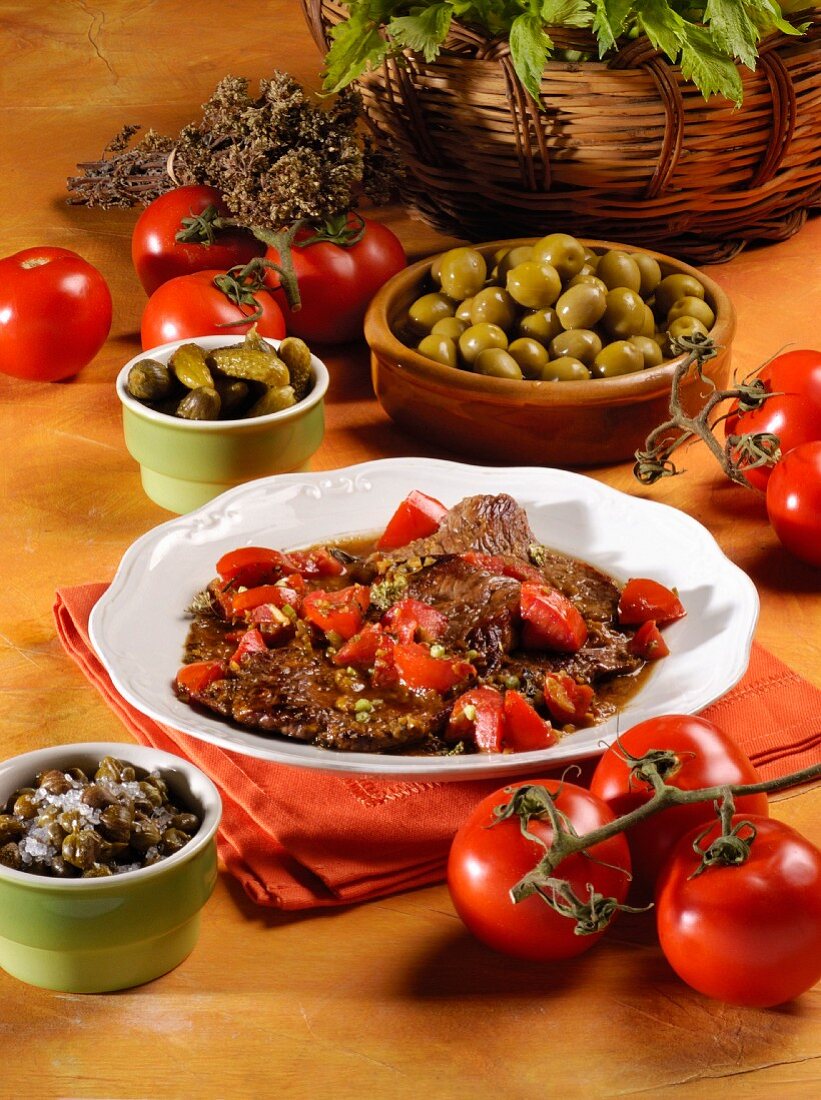 Bistecca alla siciliana (beef steak in tomato sauce with capers and olives, Italy)