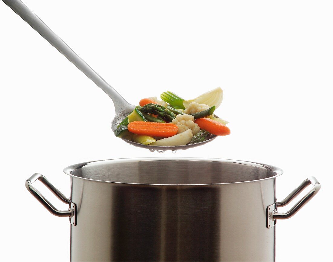 Cooked vegetables on a draining spoon