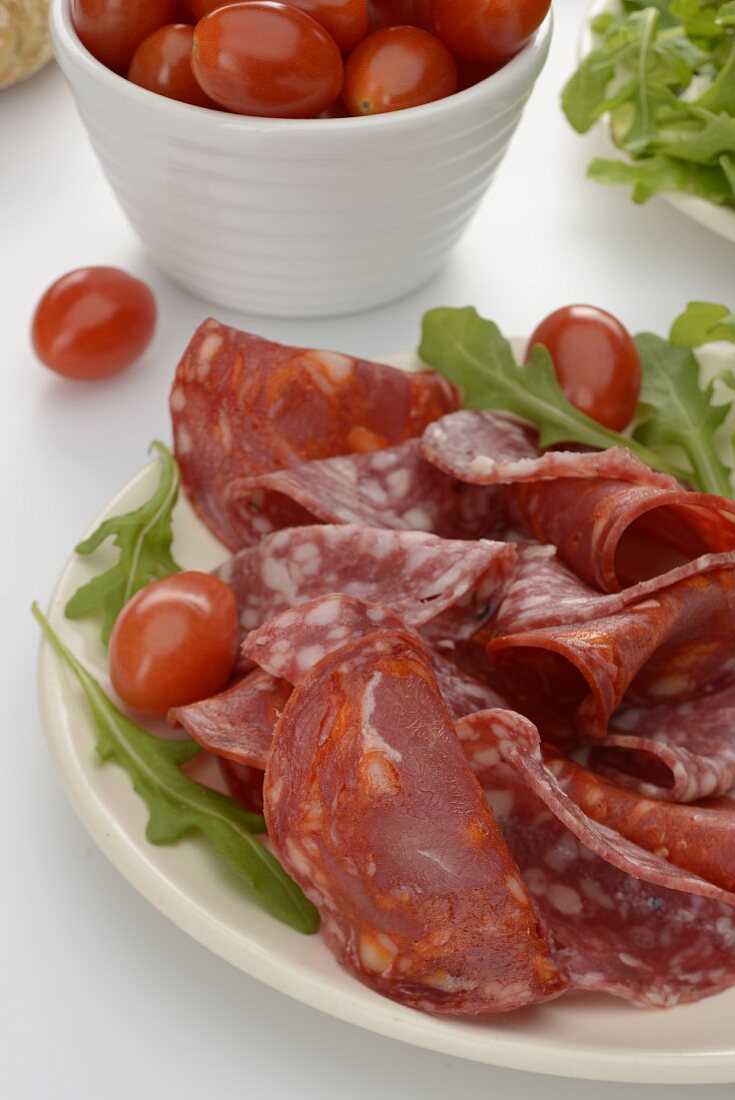 Two types of salami with cherry tomatoes on a plate