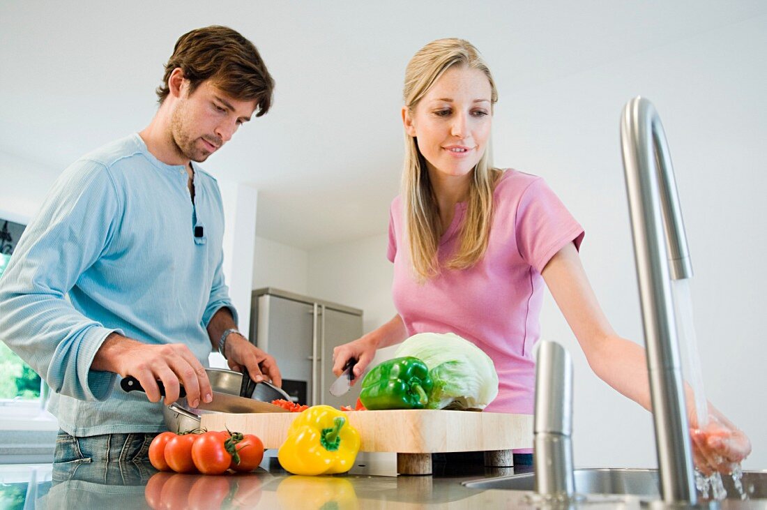 Young couple preparing food in kitchen