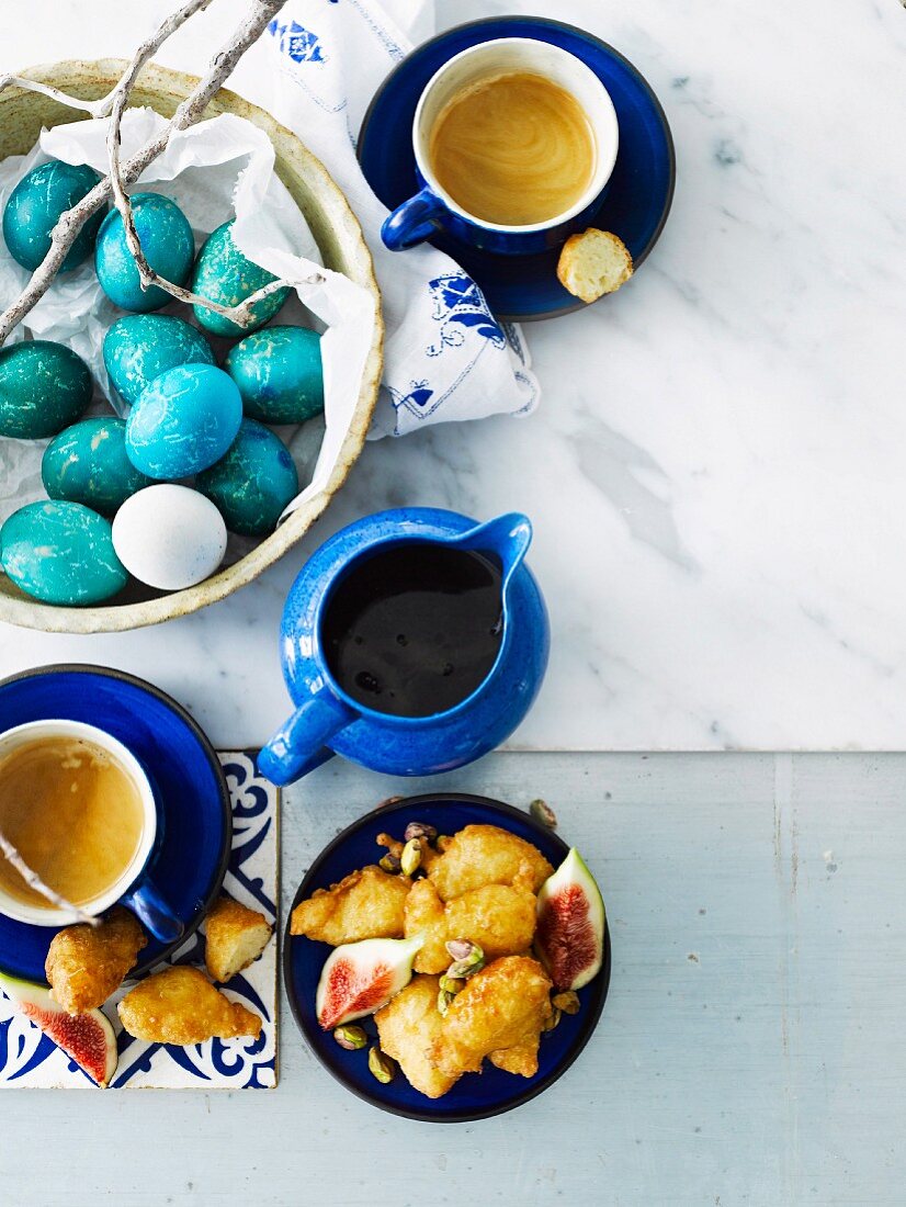 Loukoumades with figs and syrup, brightly coloured eggs for Easter, and coffee (Greece)